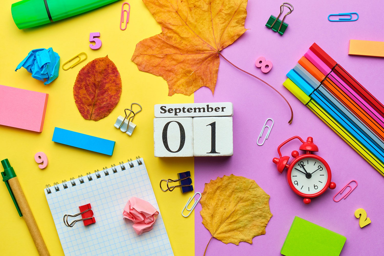 Calendar icon surrounded by leaves, pencils and other school supplies.