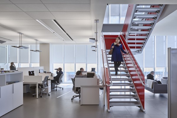Image of a woman walking down stairs in an office space.