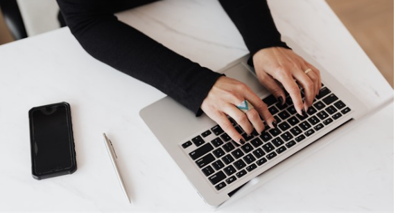 Image of woman typing on laptop keyboard