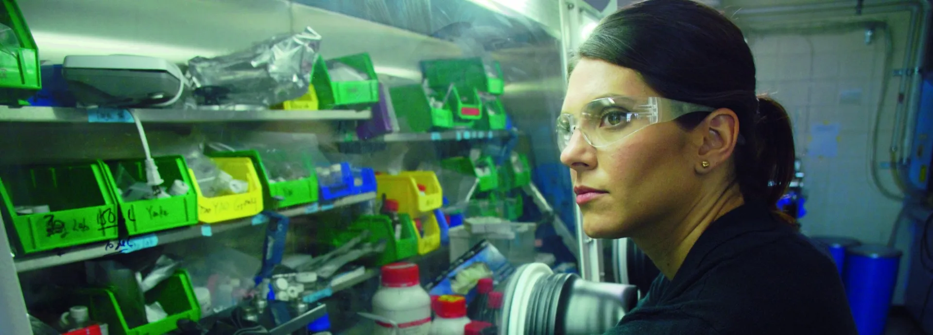 Image of woman accessing secured materials with her hands placed through gloved access points in a case.