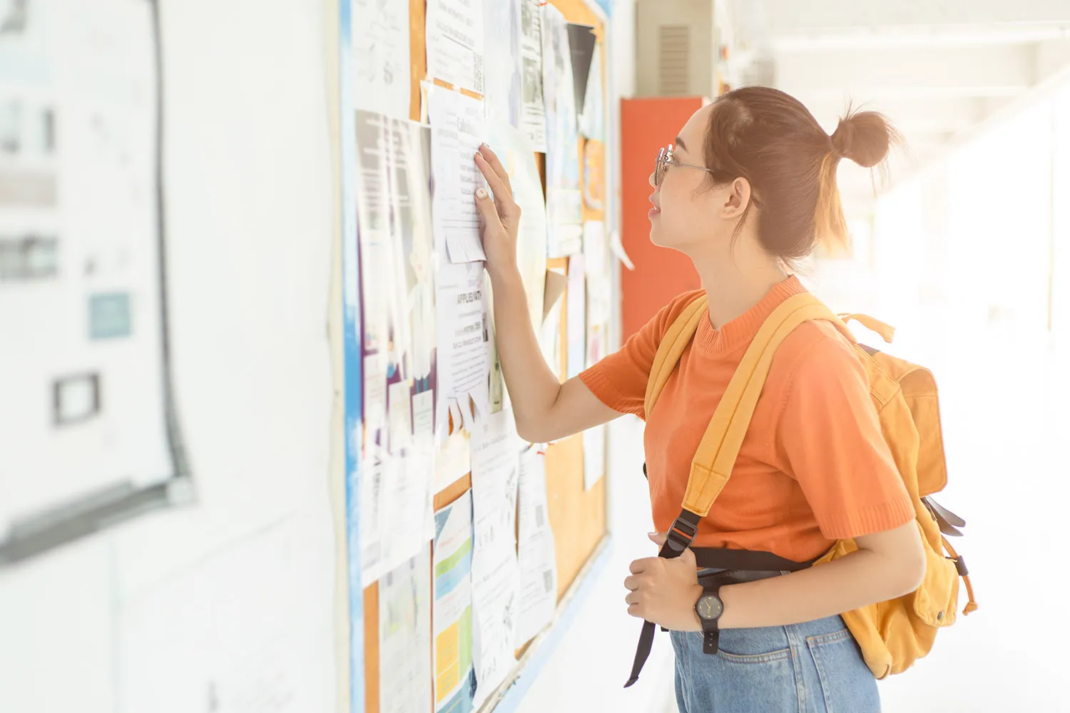 Student checks bulletin board for job postings. 