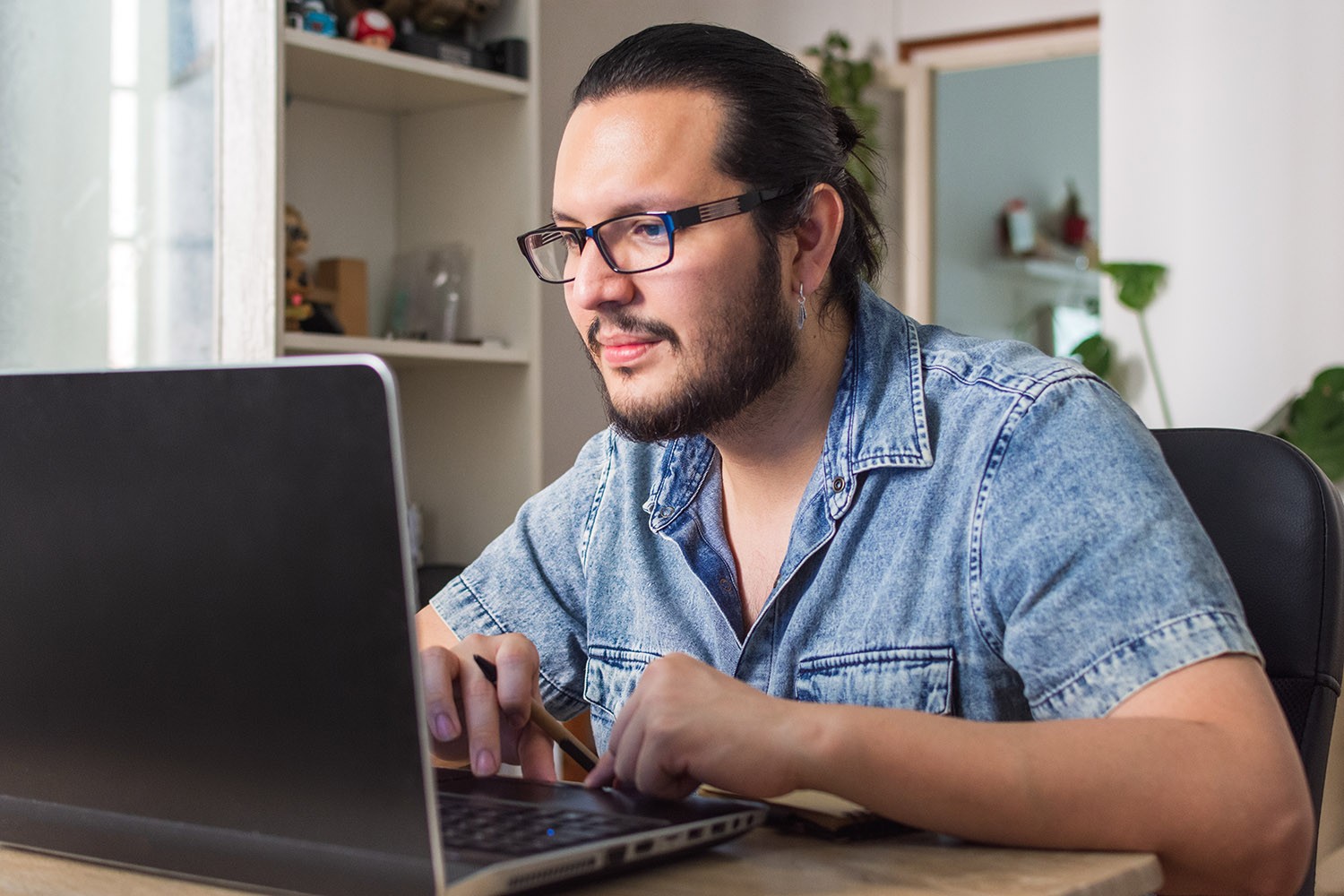 Student works on laptop in his home