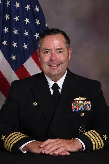 Headshot of Capt. Farrell with an American Flag in the background